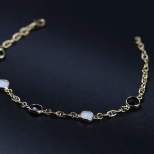 Zlatna narukvica sa belim i crnim detaljima